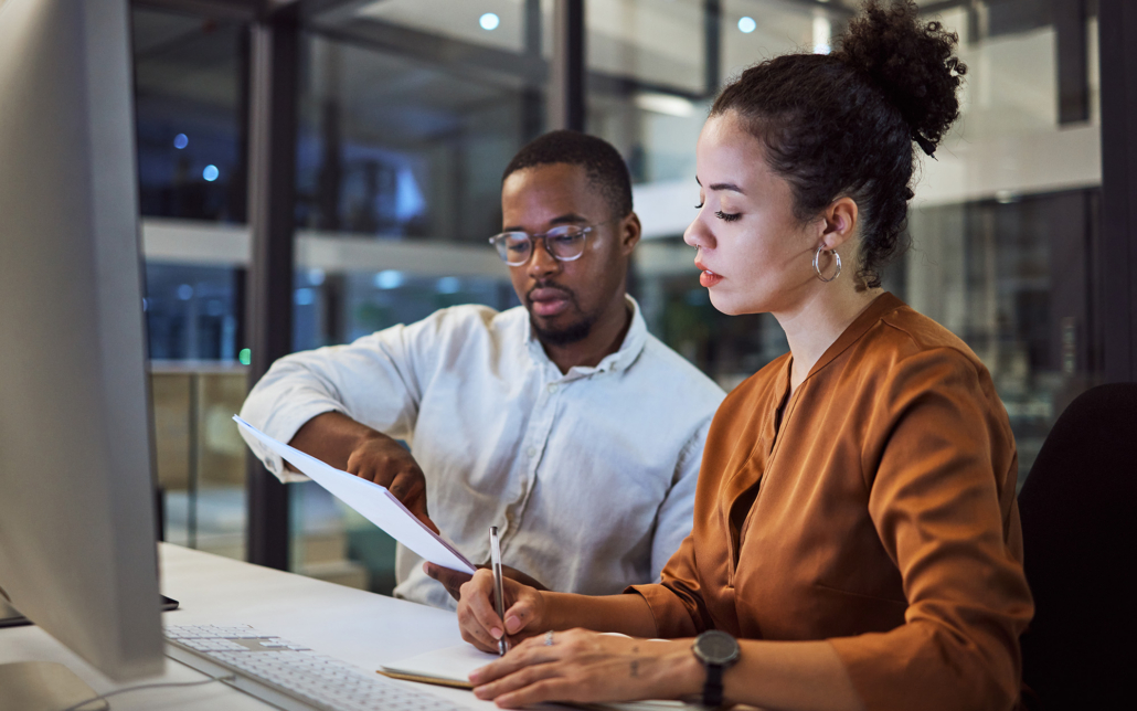 Two Business Workers Looking At Paperwork