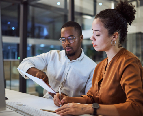 Two Business Workers Looking At Paperwork
