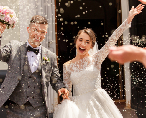 Married Couple Walking Through Flower Pedals Thrown In The Air
